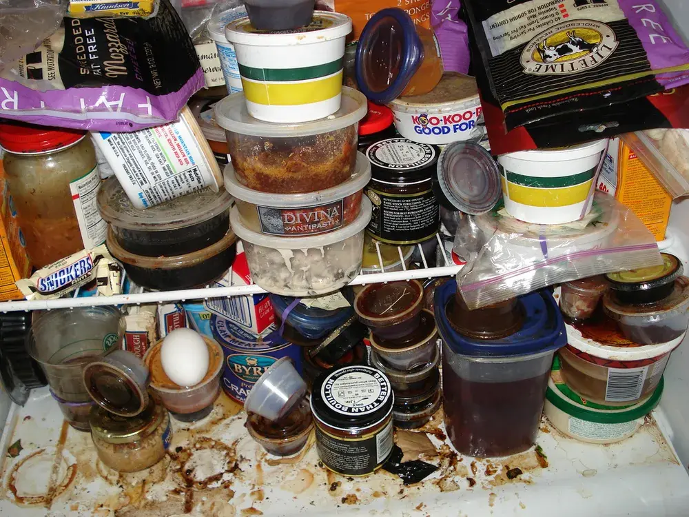 A heavily soiled, cluttered refrigerator that needs a deep clean